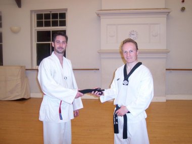 Mr Coombs receives his Black Belt from Master Evans